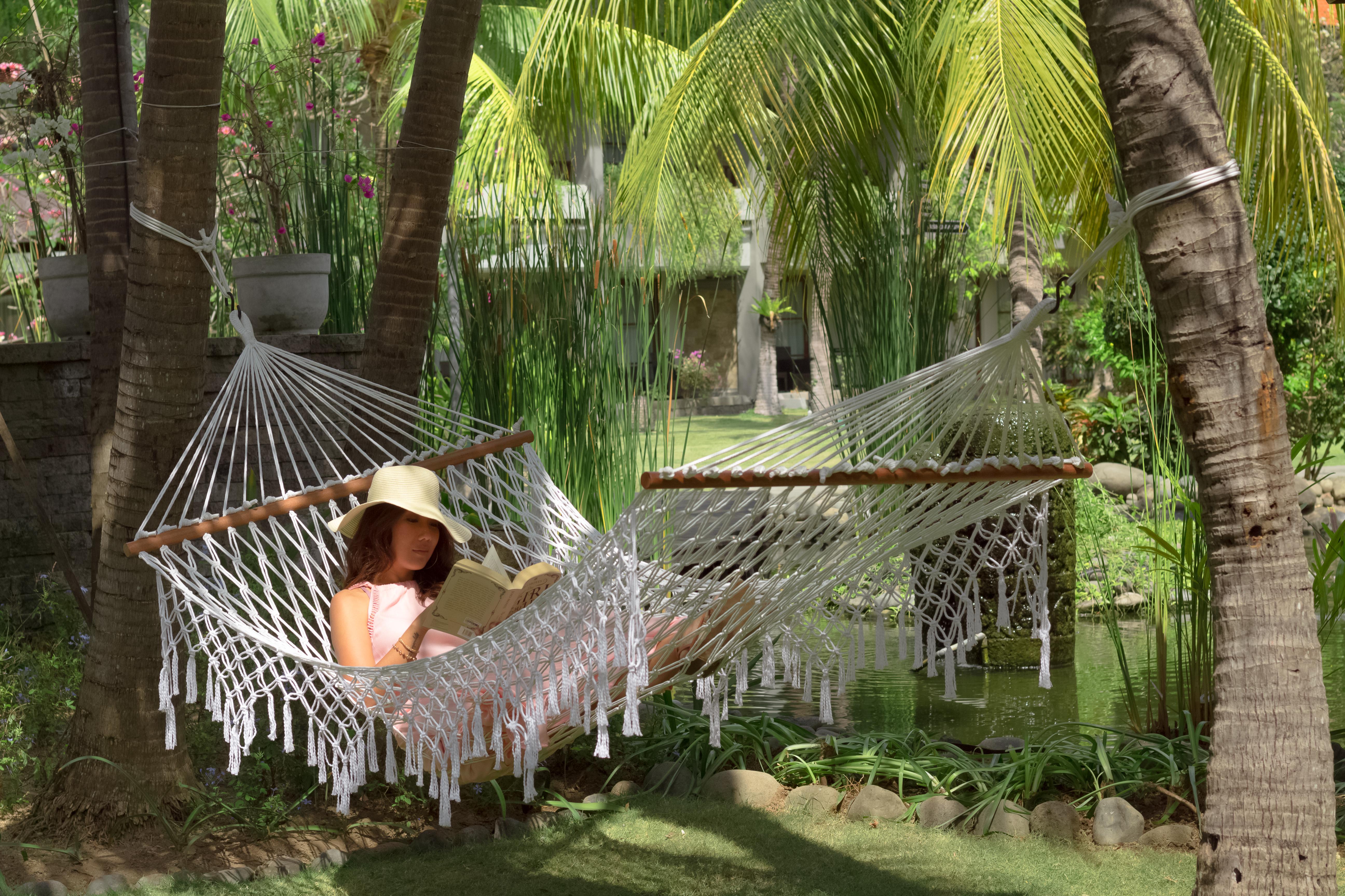 バリ ダイナスティ リゾート クタ エクステリア 写真 A woman relaxing in a hammock